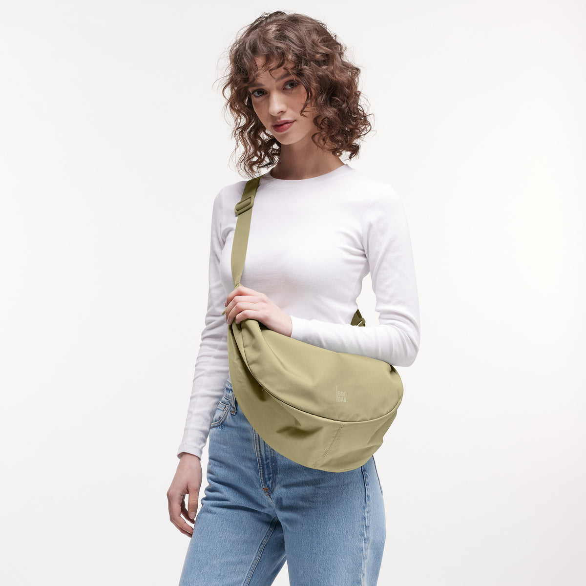 MOON BAG LARGE Tasche in nori (pastellfarbenes Pistaziengrün) von einer Frau crossbody getragen.