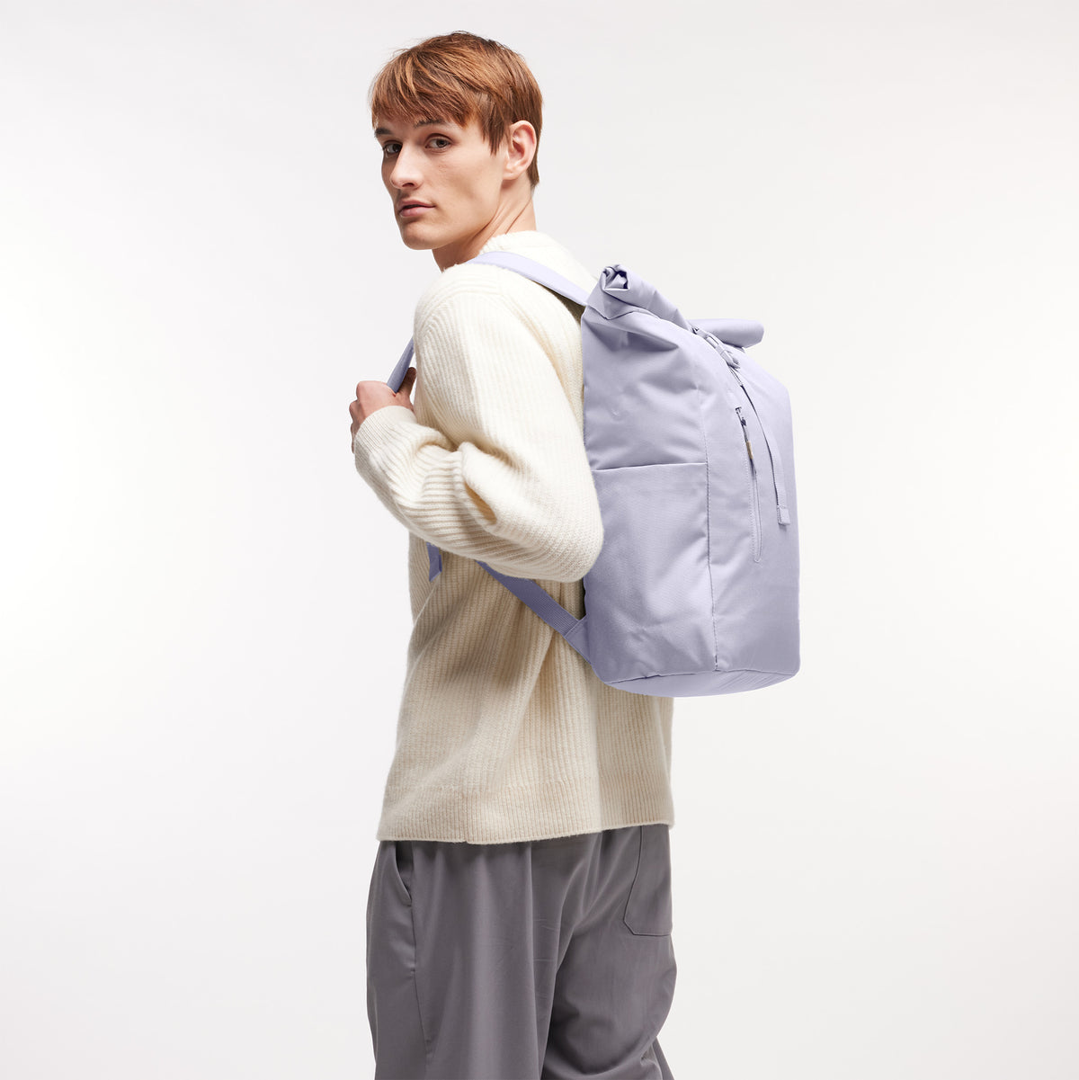 ROLLTOP EASY Rucksack in purple coral (pastellfarbenes helles Flieder) von einem Mann als Rucksack auf dem Rücken getragen.