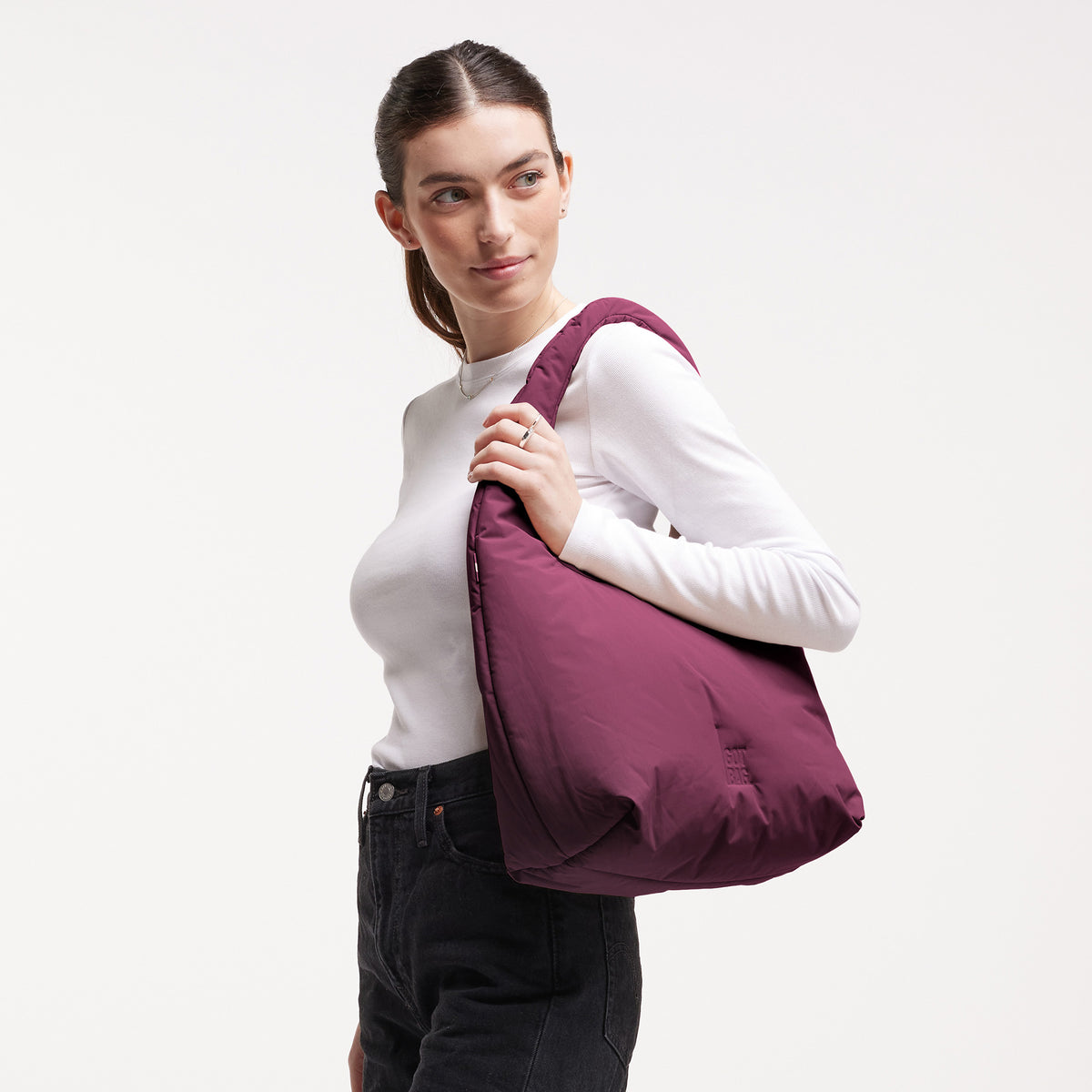 CLOUD SHOULDER BAG Tasche in kraken (Weinrot) von einer Frau über der Schulter getragen.