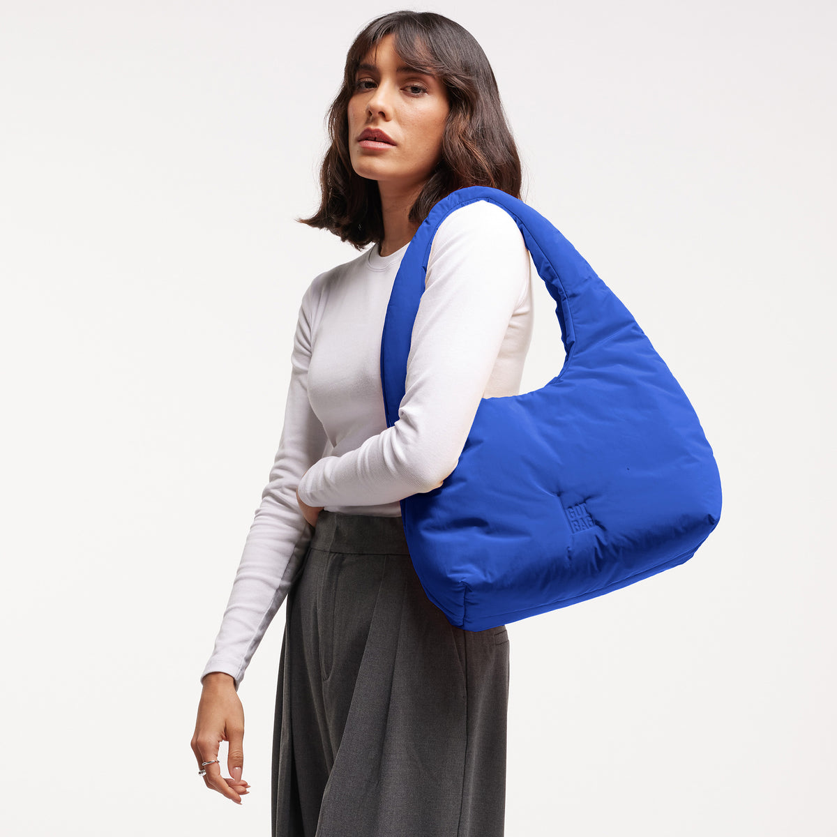 CLOUD SHOULDER Tasche in cobalt (leuchtendes Kobaltblau) von einer Frau über der Schulter getragen.
