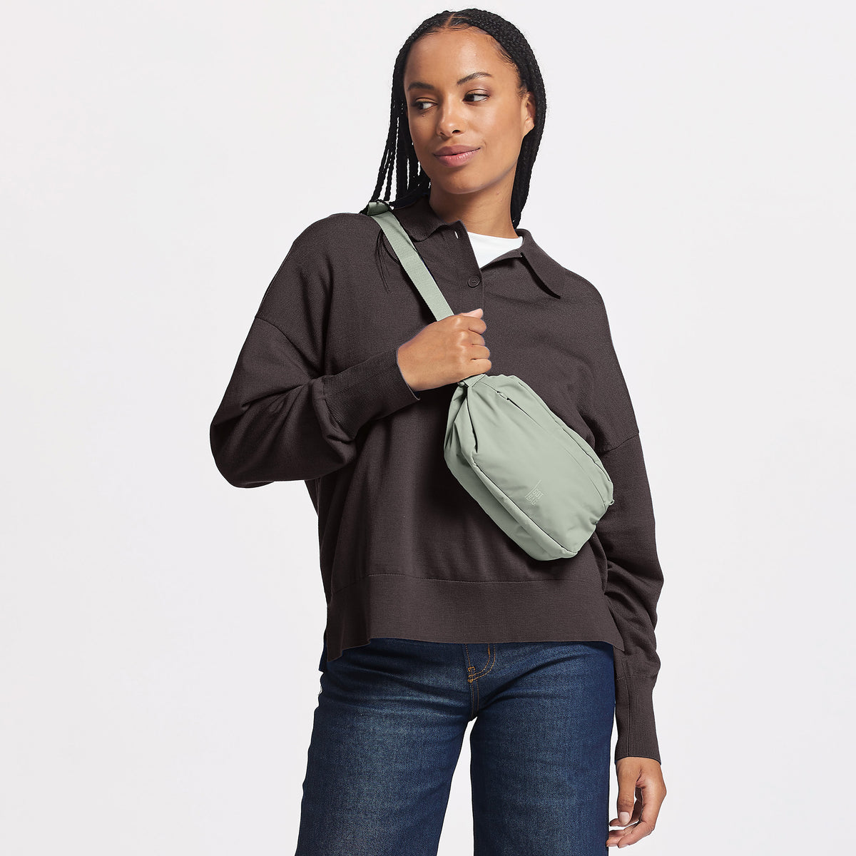 ADAPT SLING BAG Tasche in bass (Salbeigrün) von einer Frau crossbody getragen.