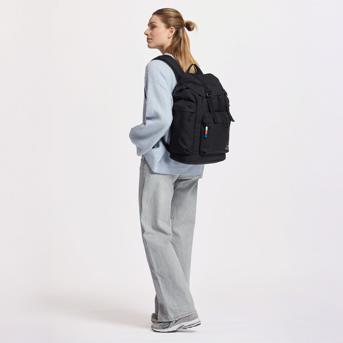 FLAP PACK LARGE Rucksack in black (Schwarz) von einer Frau auf dem Rücken getragen.