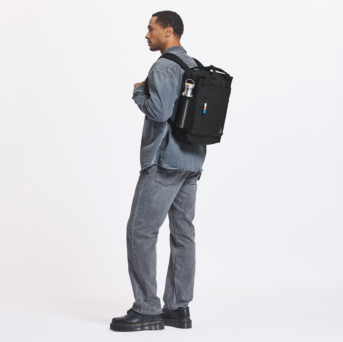 FLOW PACK Rucksack in black (Schwarz) von einem Mann auf dem Rücken getragen.