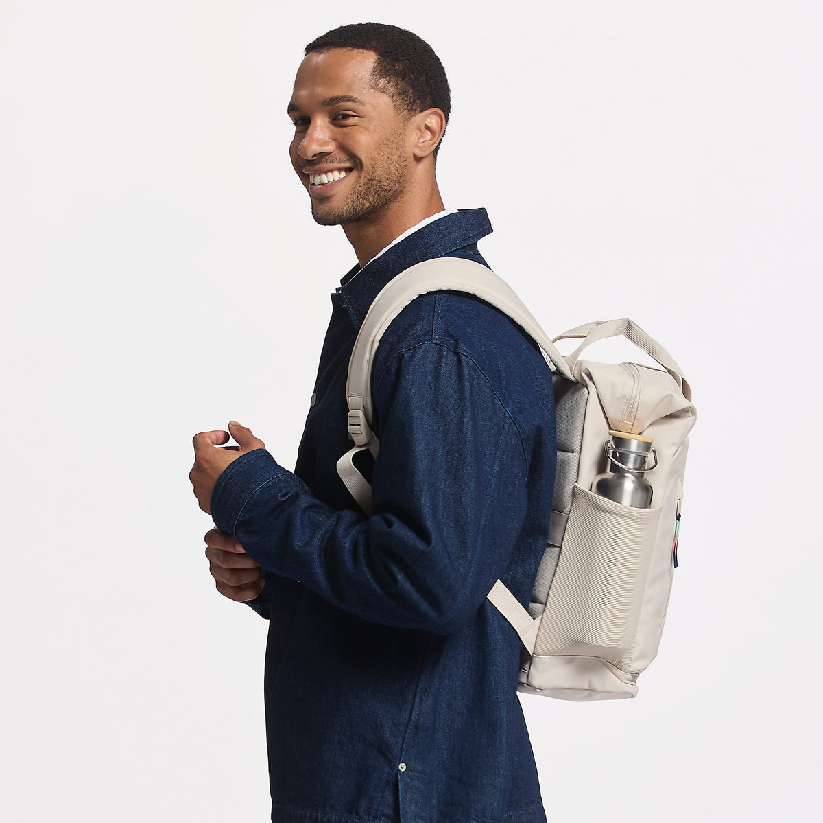 FLOW PACK Rucksack in soft shell (warmes Cremeweiß) von einem Mann auf dem Rücken getragen.