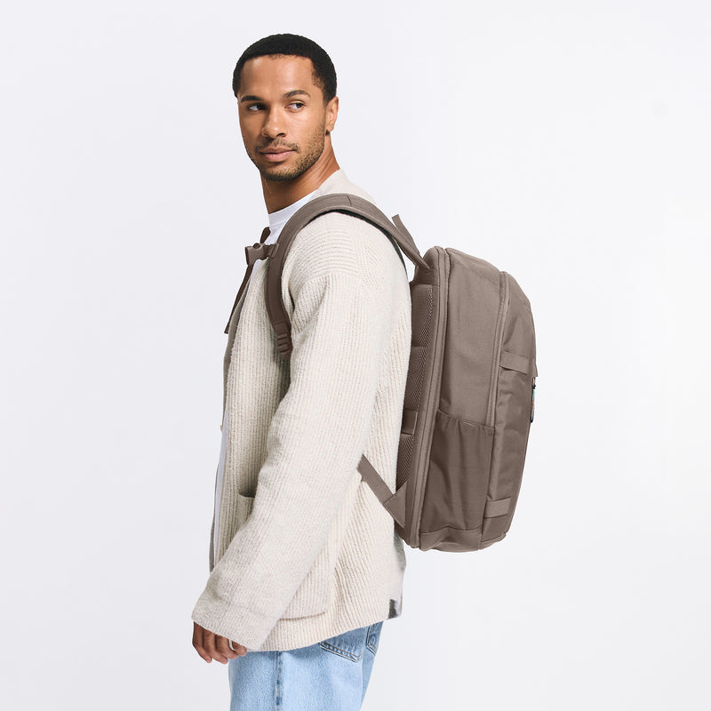 HYBRID PACK Rucksack in oyster (klassisches Taupe-Braun) von einem Mann auf dem Rücken getragen.