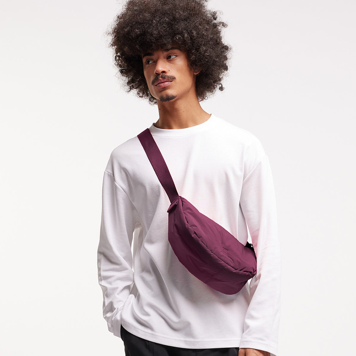 CLOUD MOON BAG SMALL Tasche in kraken (Weinrot) von einem Mann crossbody getragen.