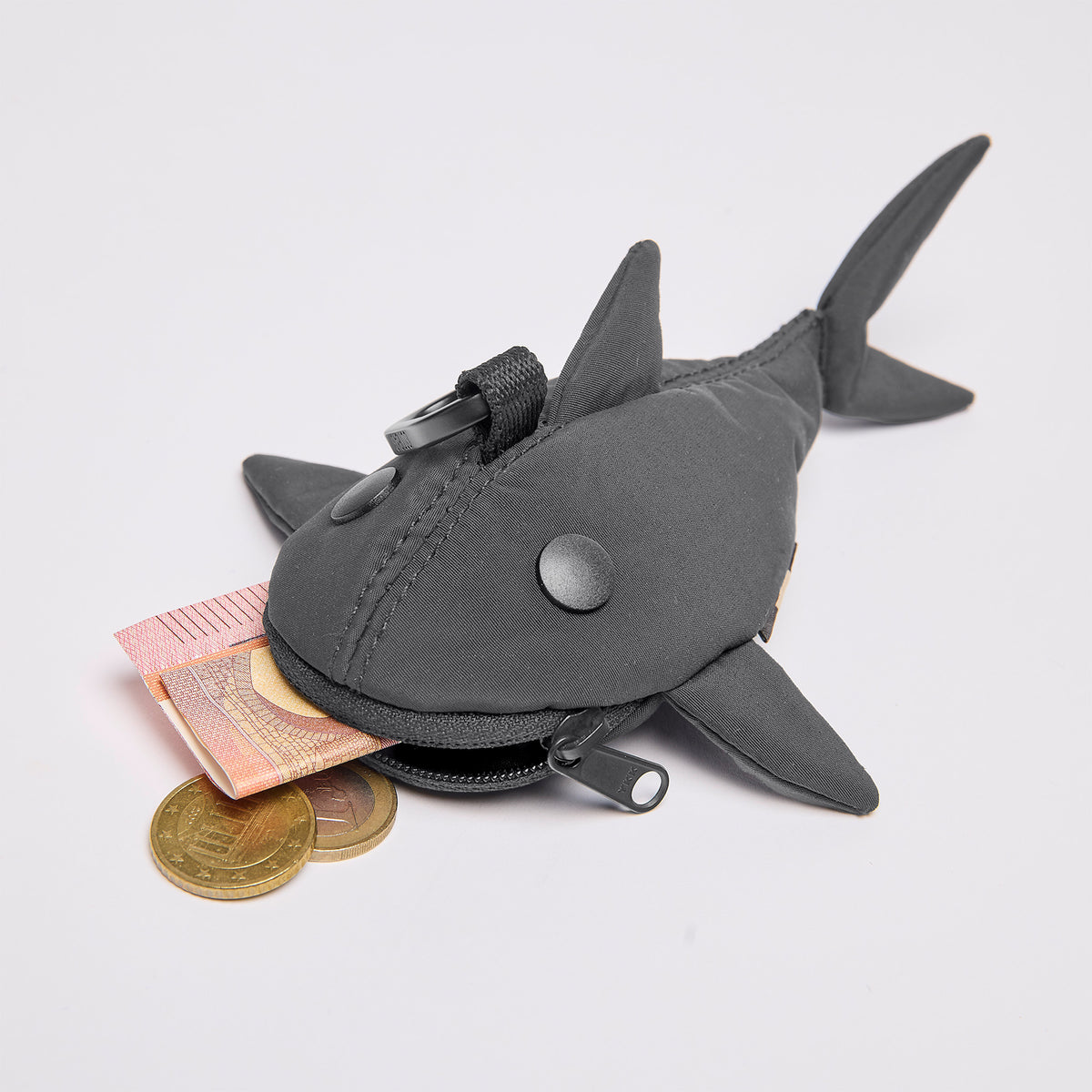 CHARM SHARK Accessoire in shark (Dunkelgrau) mit geöffnetem Reißverschluss, aus dem Geldscheine und Münzen ragen.