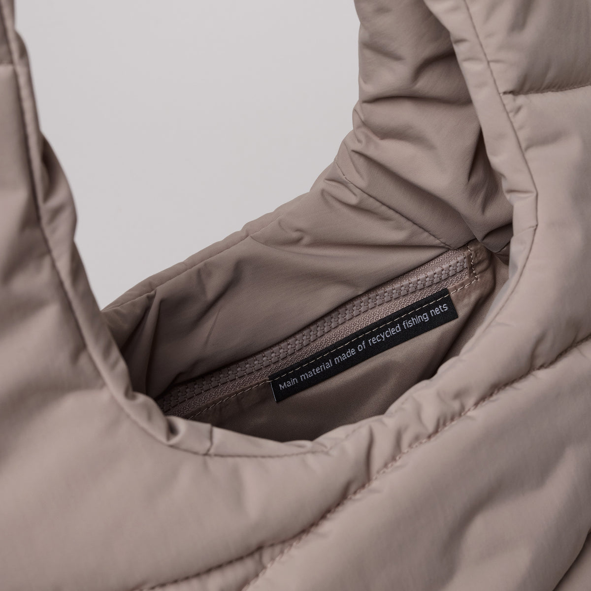 WAVY PUFFER SHOULDER BAG Tasche in oyster (klassisches Taupe-Braun) als Detailaufnahme des Innenbereichs.