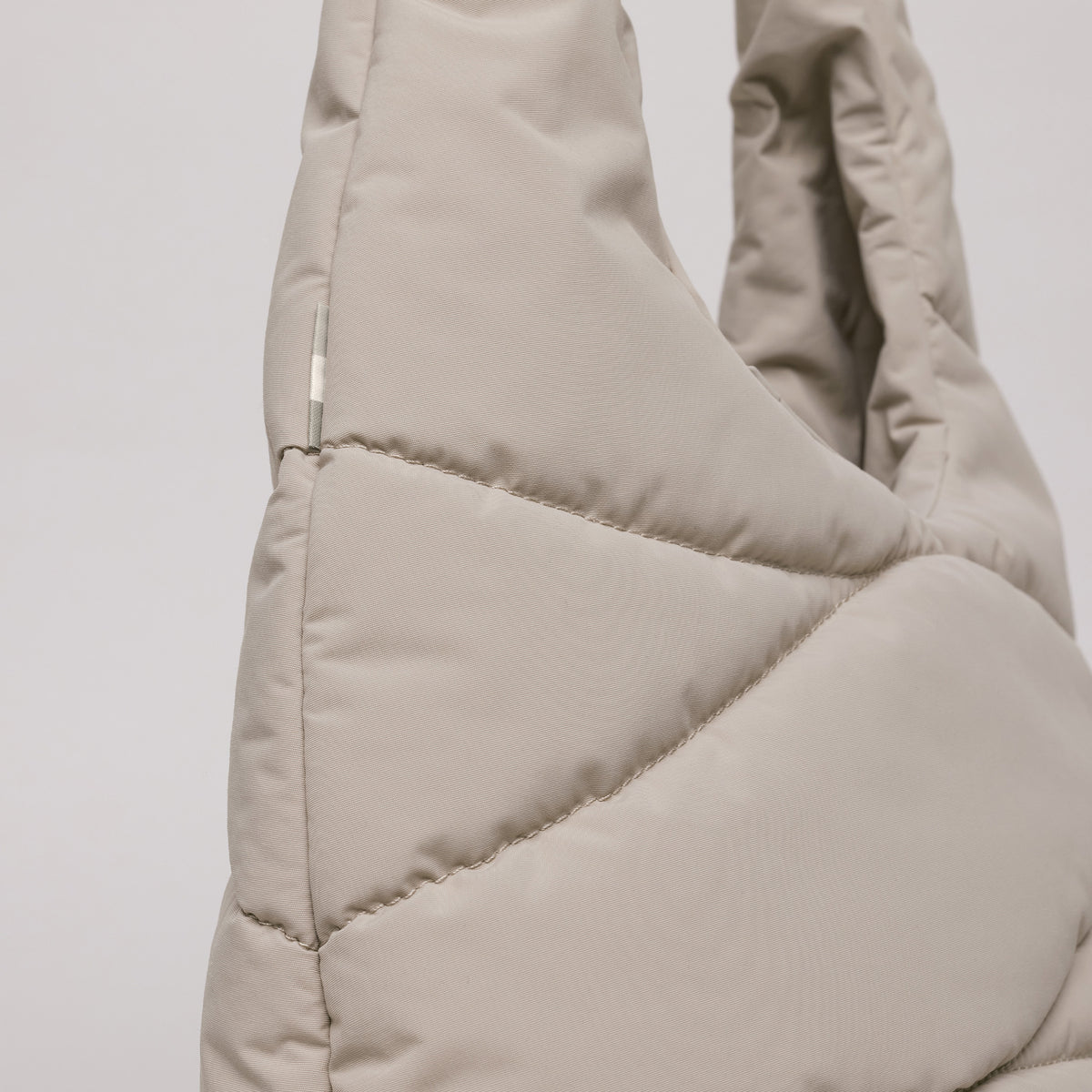 WAVY PUFFER SHOULDER BAG Tasche in scallop (helles Beige) als Detailaufnahme.