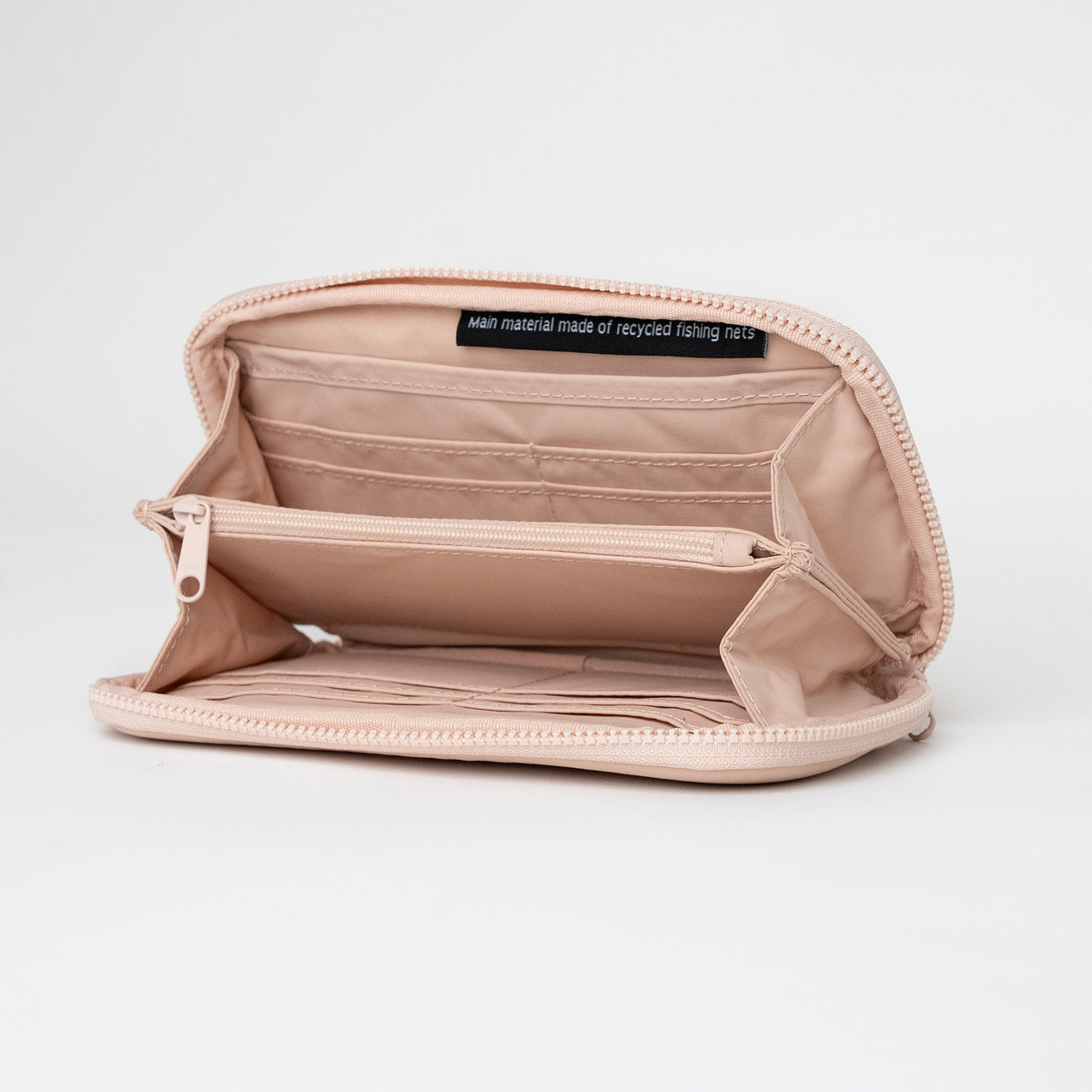 WALLET Accessoires in pearl (helles Puder-Rosa), geöffnet, innen mit Hinweis auf recycelte Fischernetze.