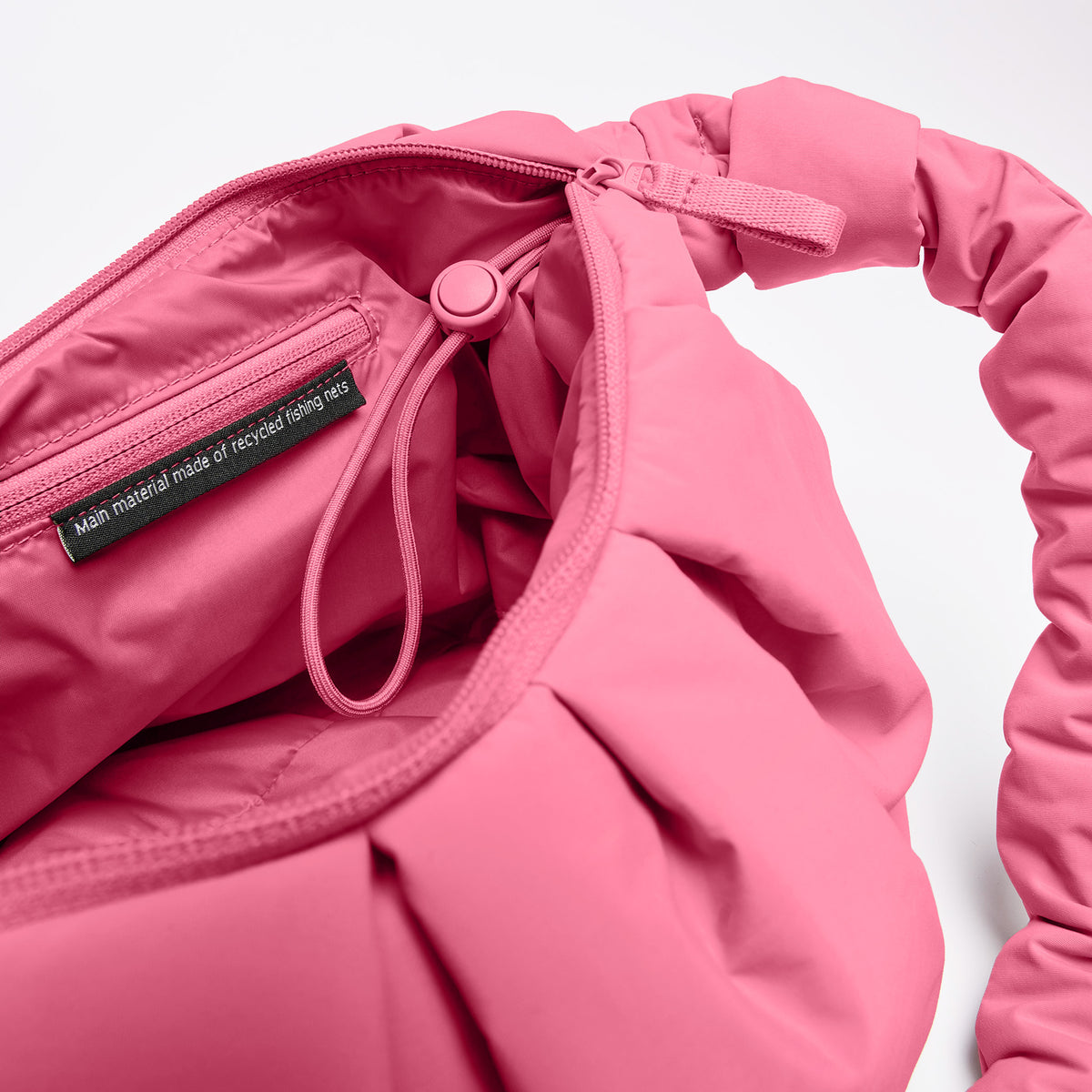 PLEAT MOON BAG LARGE Tasche in salina pink (leuchtendes Pink), Innenansicht mit Hinweis auf recyceltes Material.