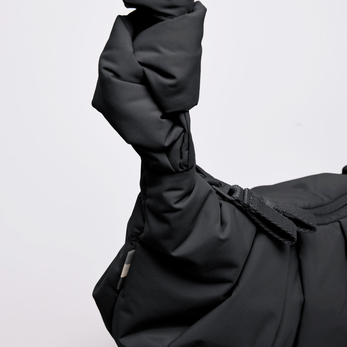 PLEAT MOON BAG SMALL Tasche in black (Schwarz) als Detailaufnahme des geknoteten Henkels.