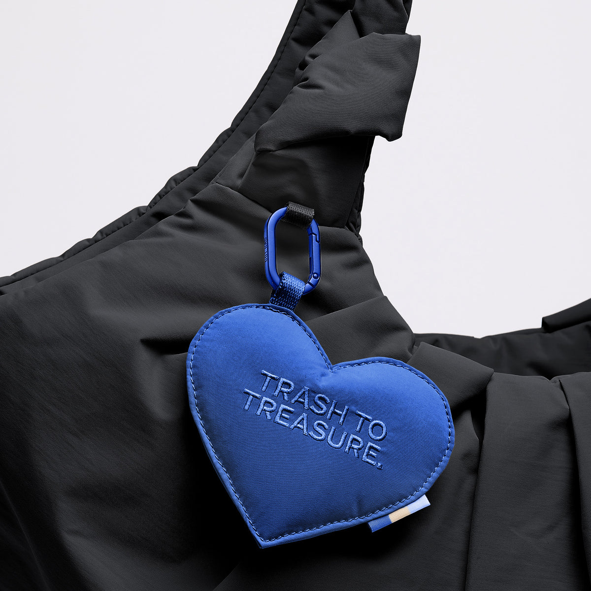 PLEAT TOTE BAG Tasche in black (Schwarz) als Detailaufnahme mit herzförmigem Anhänger TRASH TO TREASURE.