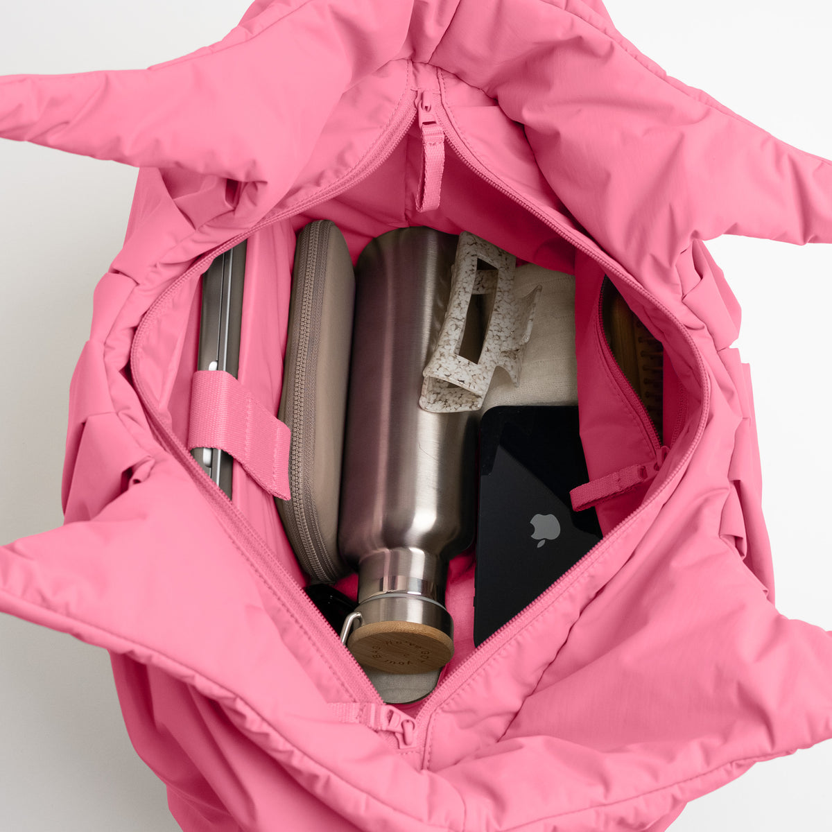PLEAT TOTE BAG Tasche in salina pink (leuchtendes Pink) Innenansicht, gefüllt mit Alltagsgegenständen.