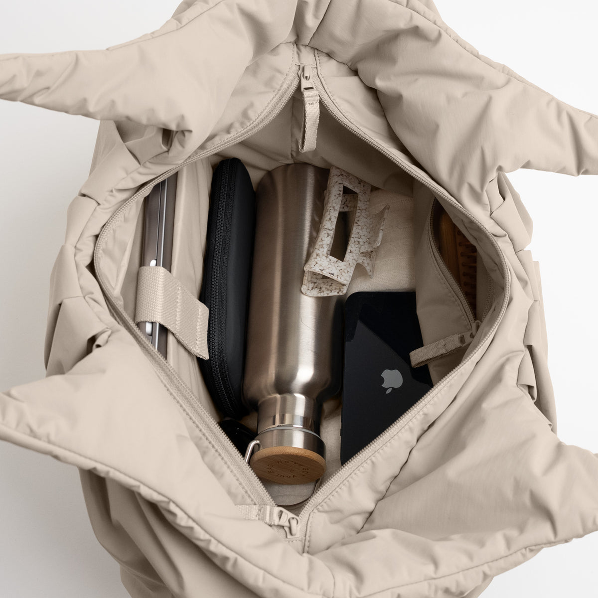 PLEAT TOTE BAG Tasche in scallop (helles Beige) offen mit Laptop und Wasserflasche.