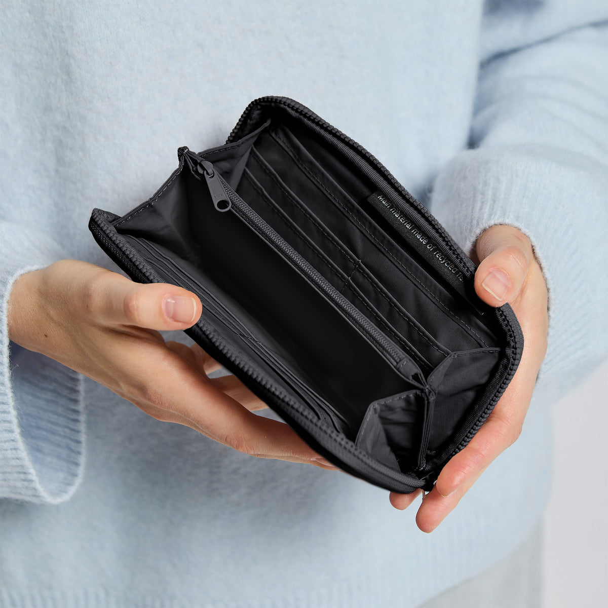 WALLET Accessoires in black (Schwarz) von einer Frau in der Hand gehalten.