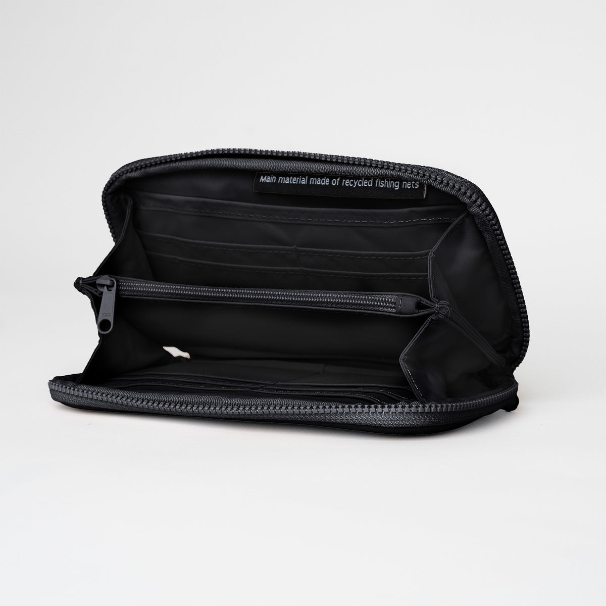 WALLET Accessoires in black (Schwarz), geöffnet, mit Aufschrift Hauptmaterial aus recycelten Fischernetzen.