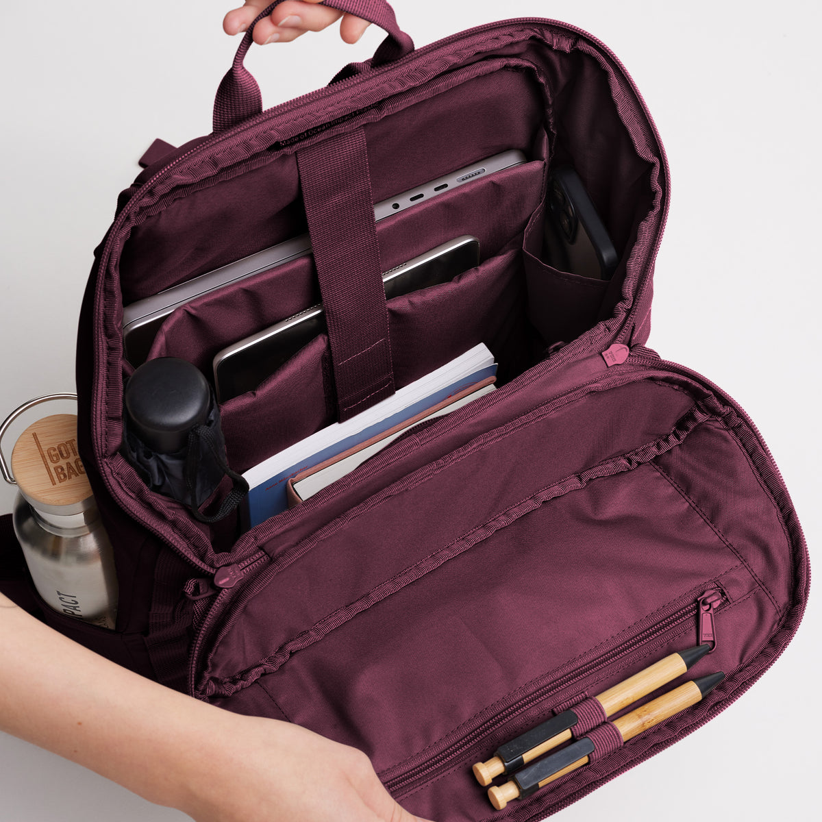 PRO PACK MONOCHROME EDITION Rucksack in kraken (Weinrot), geöffnet mit Laptop, Tablet, Büchern und Flasche im organisierten Innenraum.
