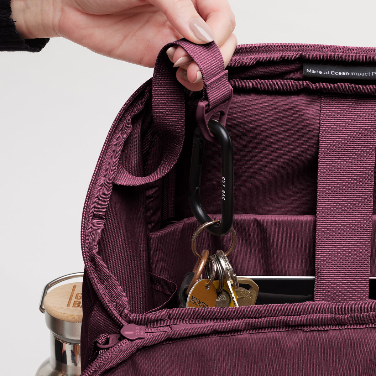 PRO PACK Monochrome Edition Rucksack in kraken (Weinrot) von einer Frau in der Hand gehalten.