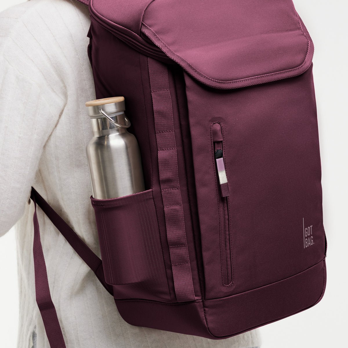 PRO PACK Rucksack in kraken (Weinrot) von einer Person auf dem Rücken getragen, mit einer Trinkflasche in der Seitentasche.