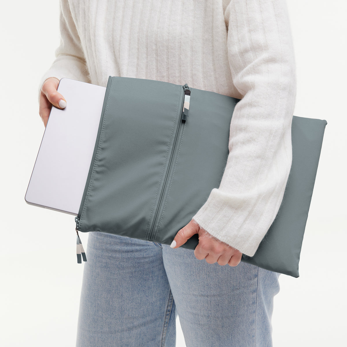 Frau hält einen Laptop in der ROLLTOP 2.0 Monochrome Edition Accessoire in basalt (graues Eisblau).