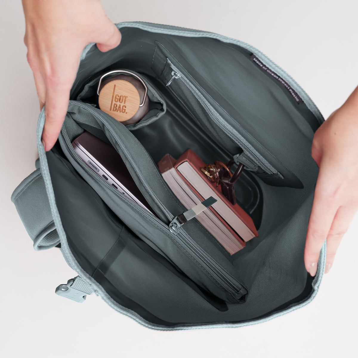 ROLLTOP LITE Rucksack in basalt (graues Eisblau) mit organisiertem Innenleben für Laptop und Flasche.
