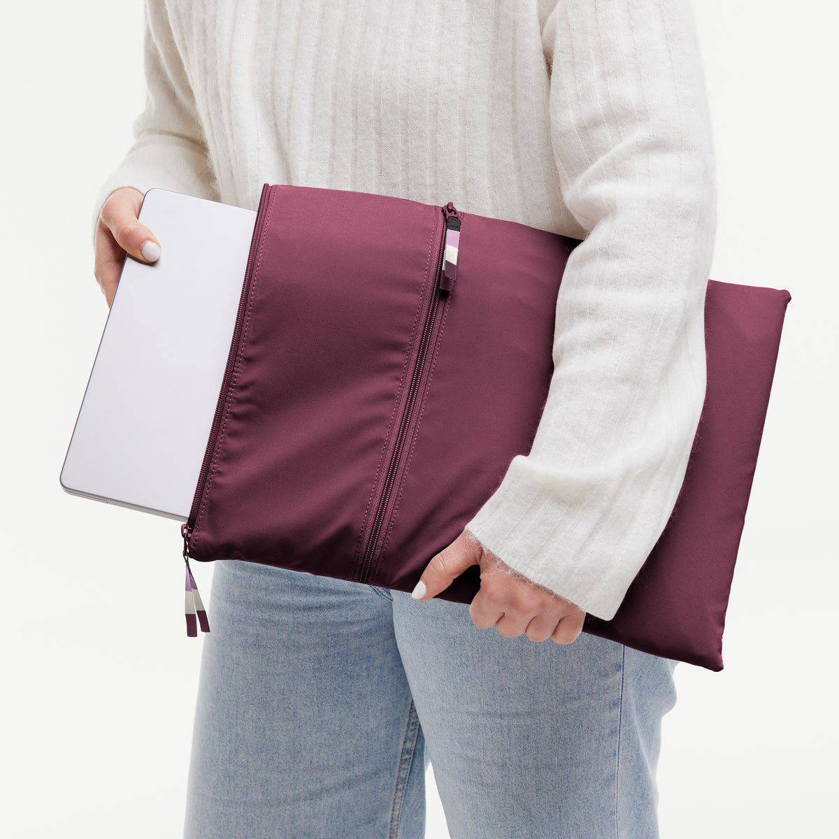 ROLLTOP LITE Accessoires in kraken (Weinrot), von einer Frau in der Hand gehalten.