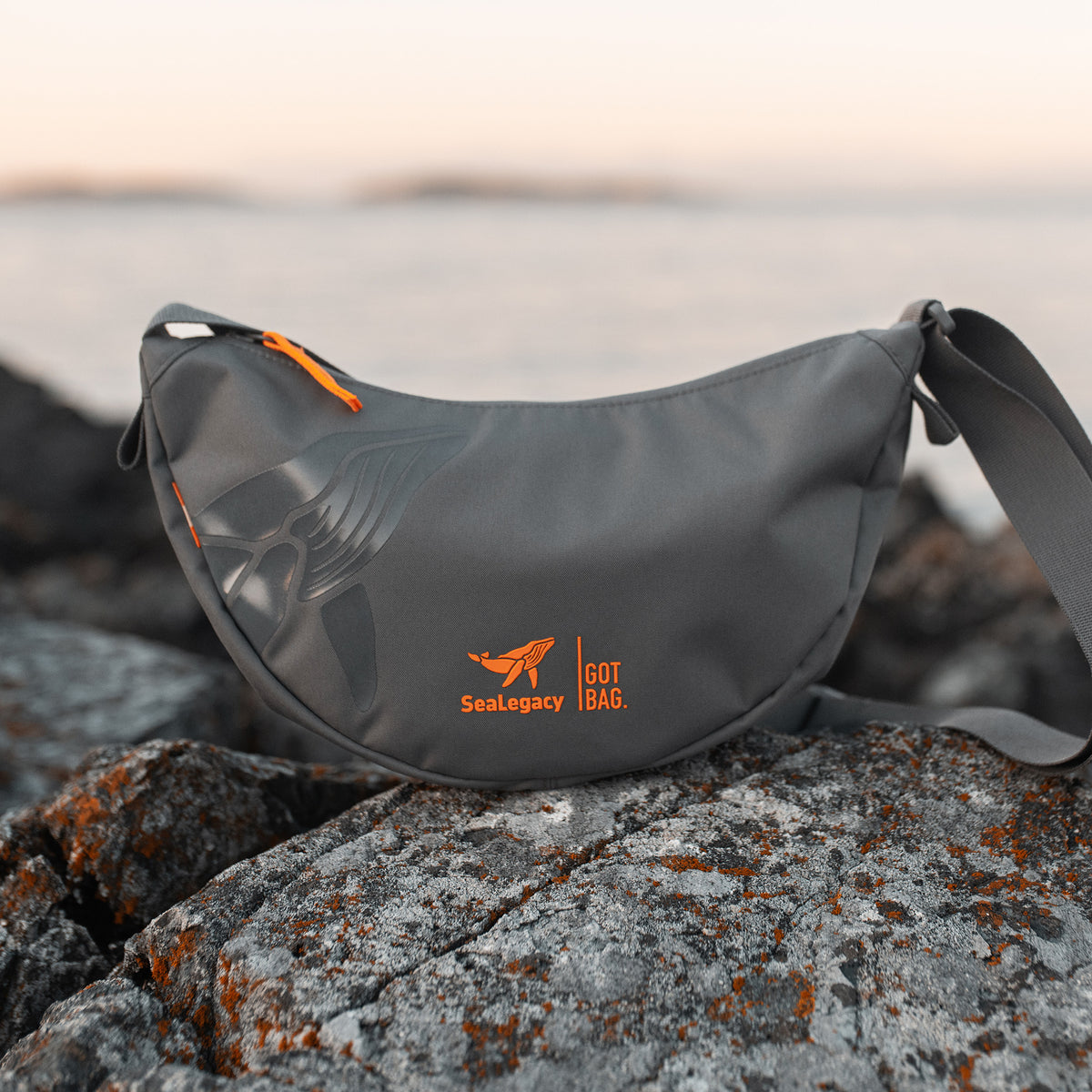 MOON BAG SMALL Tasche in shark (Dunkelgrau) auf Felsen.