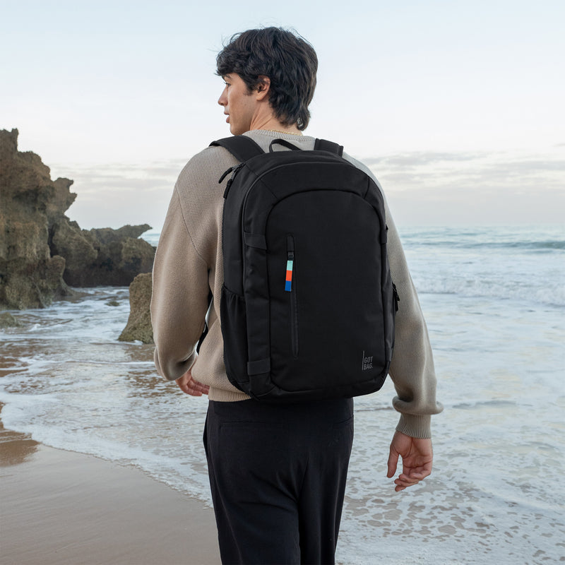 HYBRID PACK Rucksack in black (Schwarz) von einem Mann als Rucksack auf dem Rücken getragen.