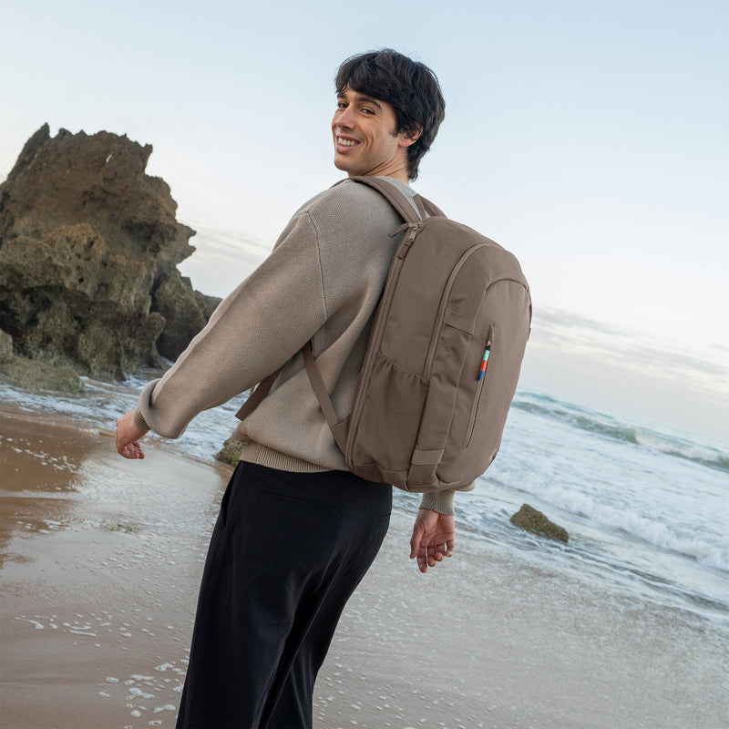 HYBRID PACK Rucksack in oyster (klassisches Taupe-Braun) von einem Mann als Rucksack auf dem Rücken getragen.