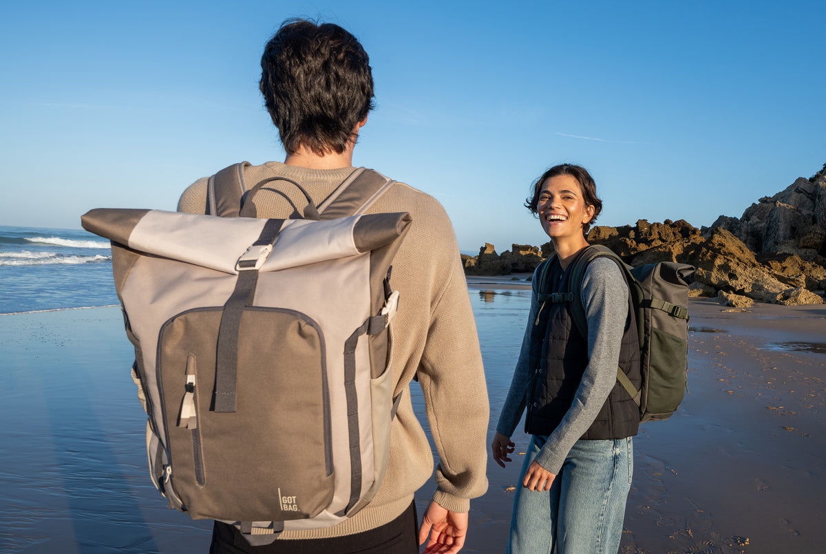 ROLLTOP ADVENTURE sac à dos en algae (vert foncé avec nuance de gris) et oyster (marron taupe) porté sur le dos par un homme.