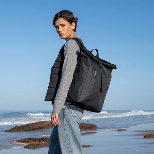 ROLLTOP EASY Monochrome Edition Rucksack in black (Schwarz) von einer Frau als Rucksack auf dem Rücken getragen.