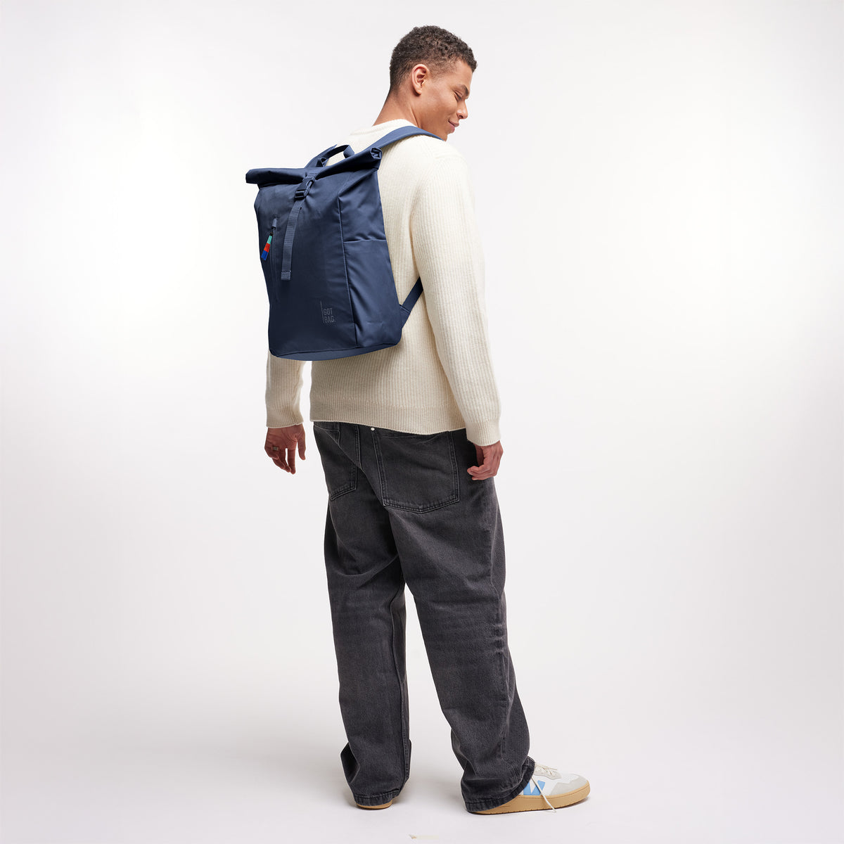 ROLLTOP EASY Rucksack in deep ocean (dunkles Marineblau) von einem Mann auf dem Rücken getragen.