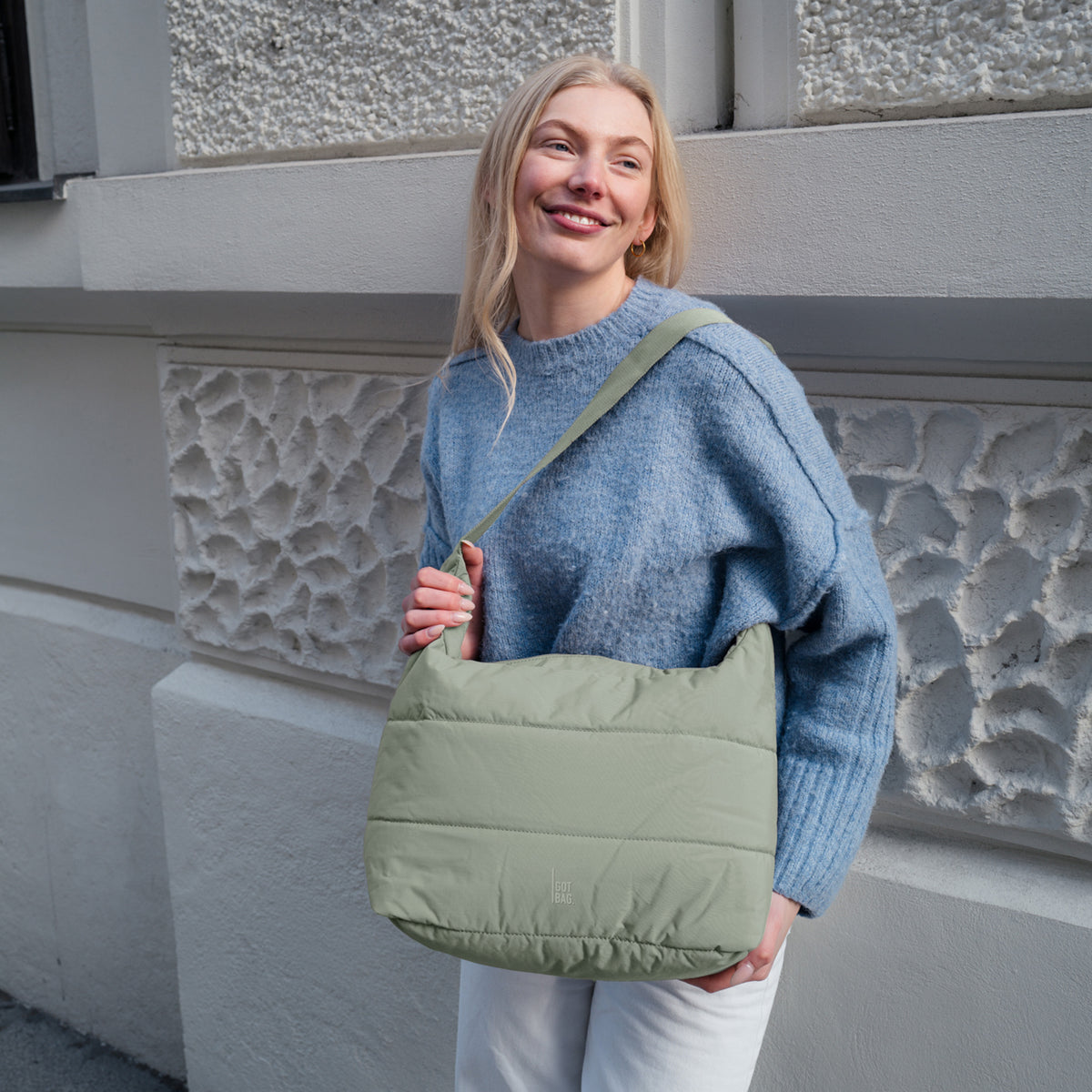 PUFFER SQUARE BAG Tasche in oyster (klassisches Taupe-Braun) von einer Frau crossbody getragen.