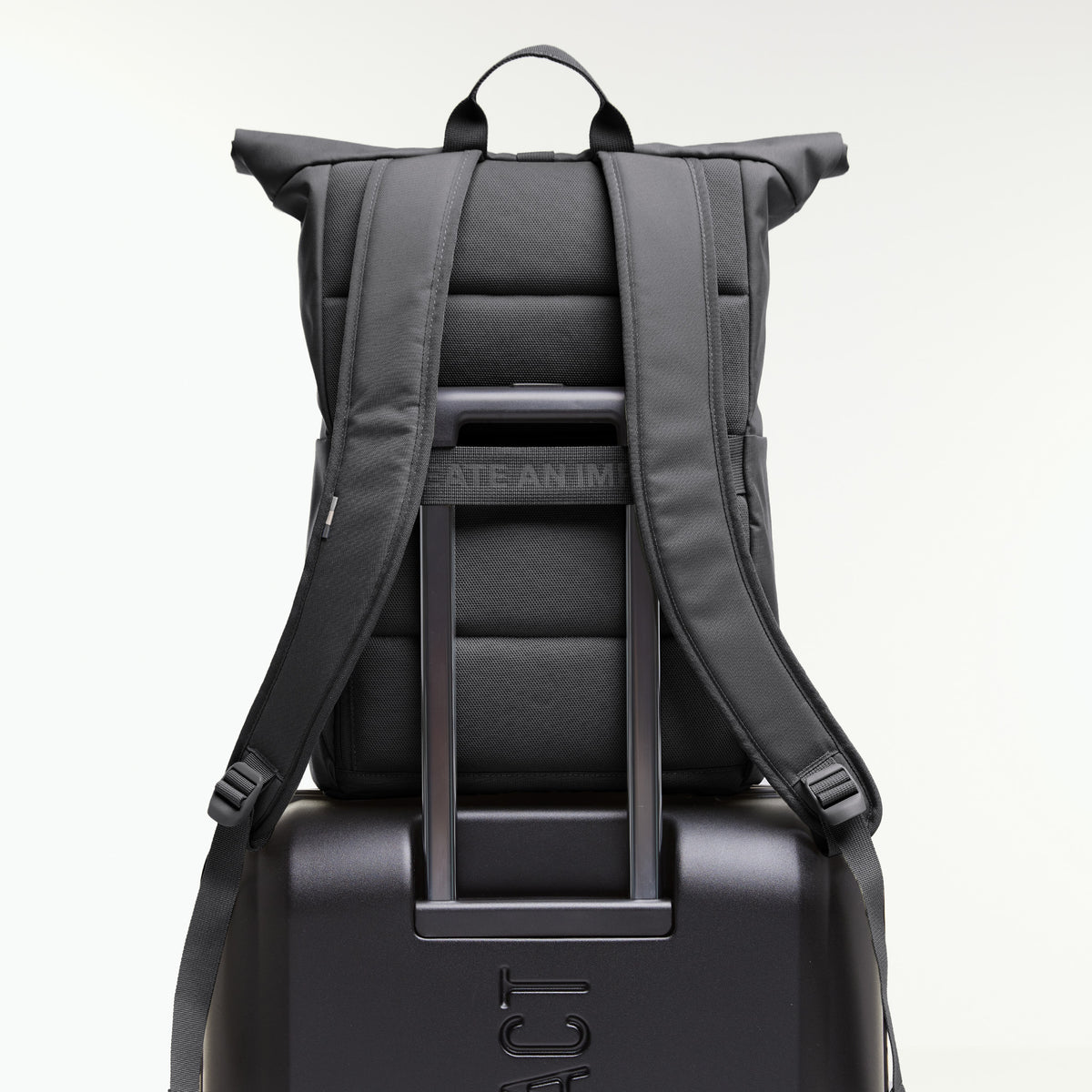 ROLLTOP EASY Rucksack in shark (Dunkelgrau) auf einem Koffer mit ausziehbarem Griff, Rückansicht.