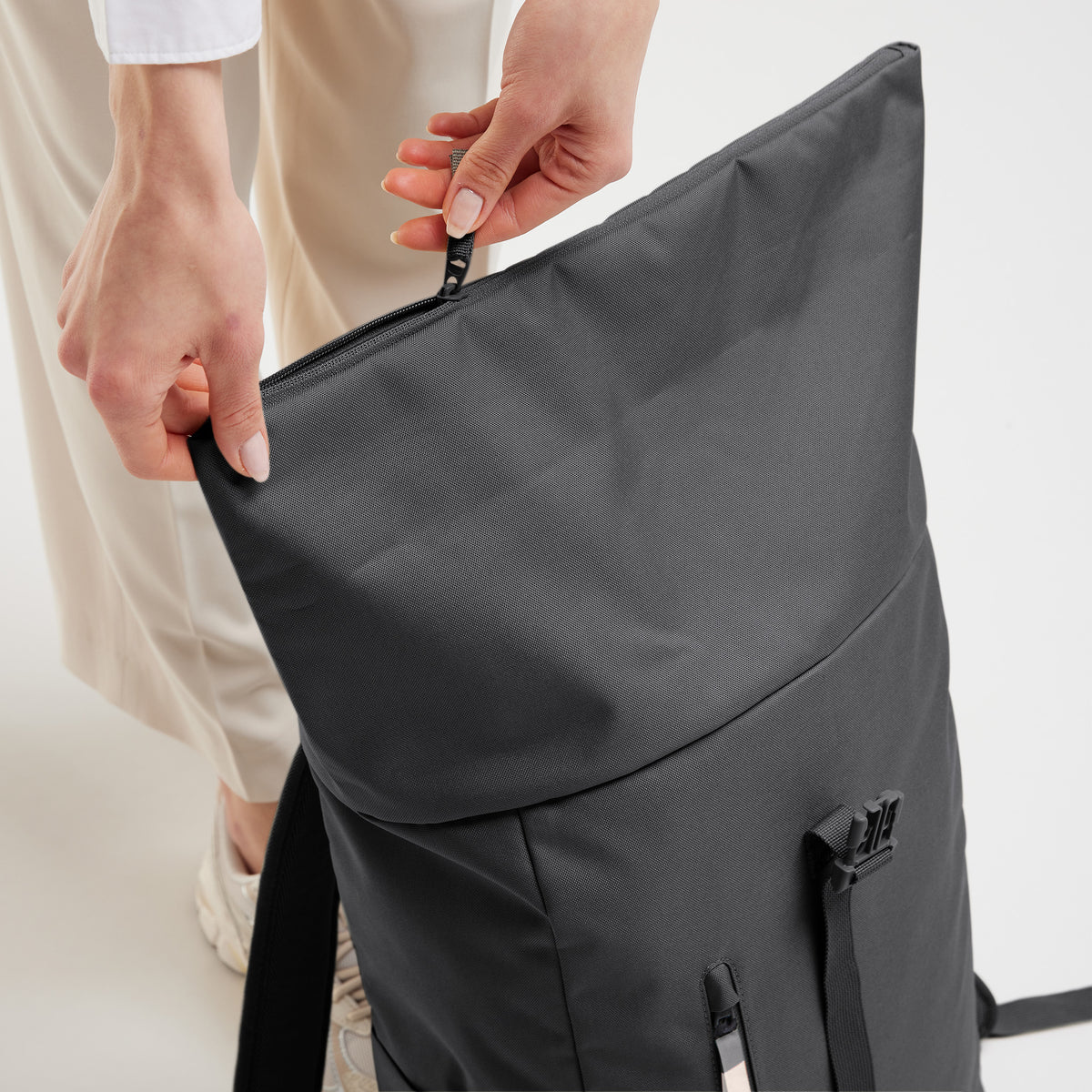 ROLLTOP EASY Rucksack in shark (Dunkelgrau) von einer Frau am Reißverschluss bedient.