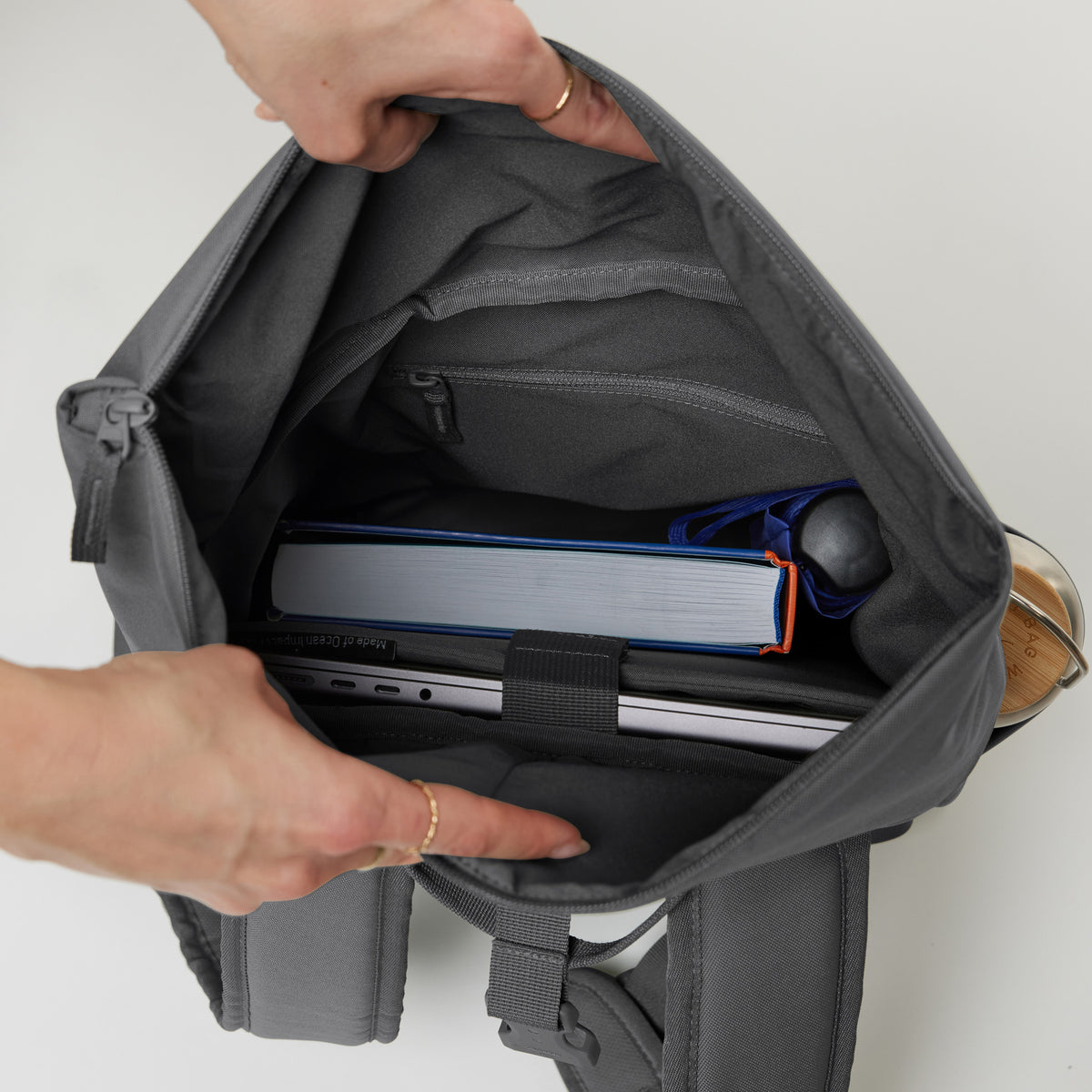 ROLLTOP EASY SMALL Monochrome Edition Rucksack in shark (Dunkelgrau) Innenansicht mit Laptop, Buch und Flasche.
