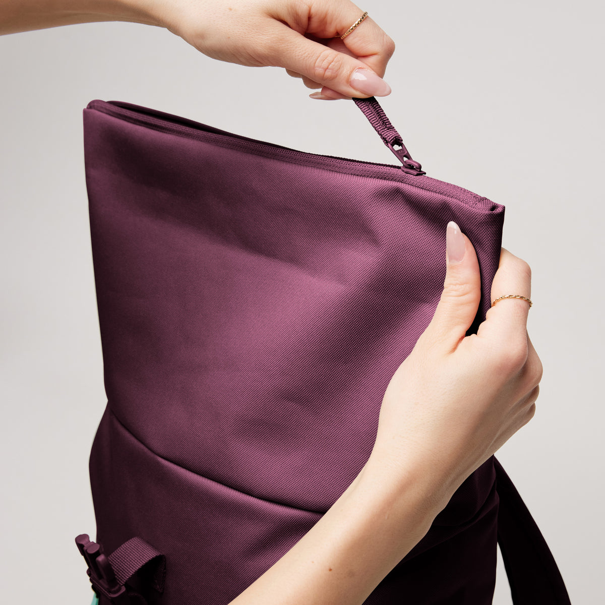 ROLLTOP EASY SMALL Rucksack in kraken (Weinrot) als Detailaufnahme, von einer Frau geöffnet.