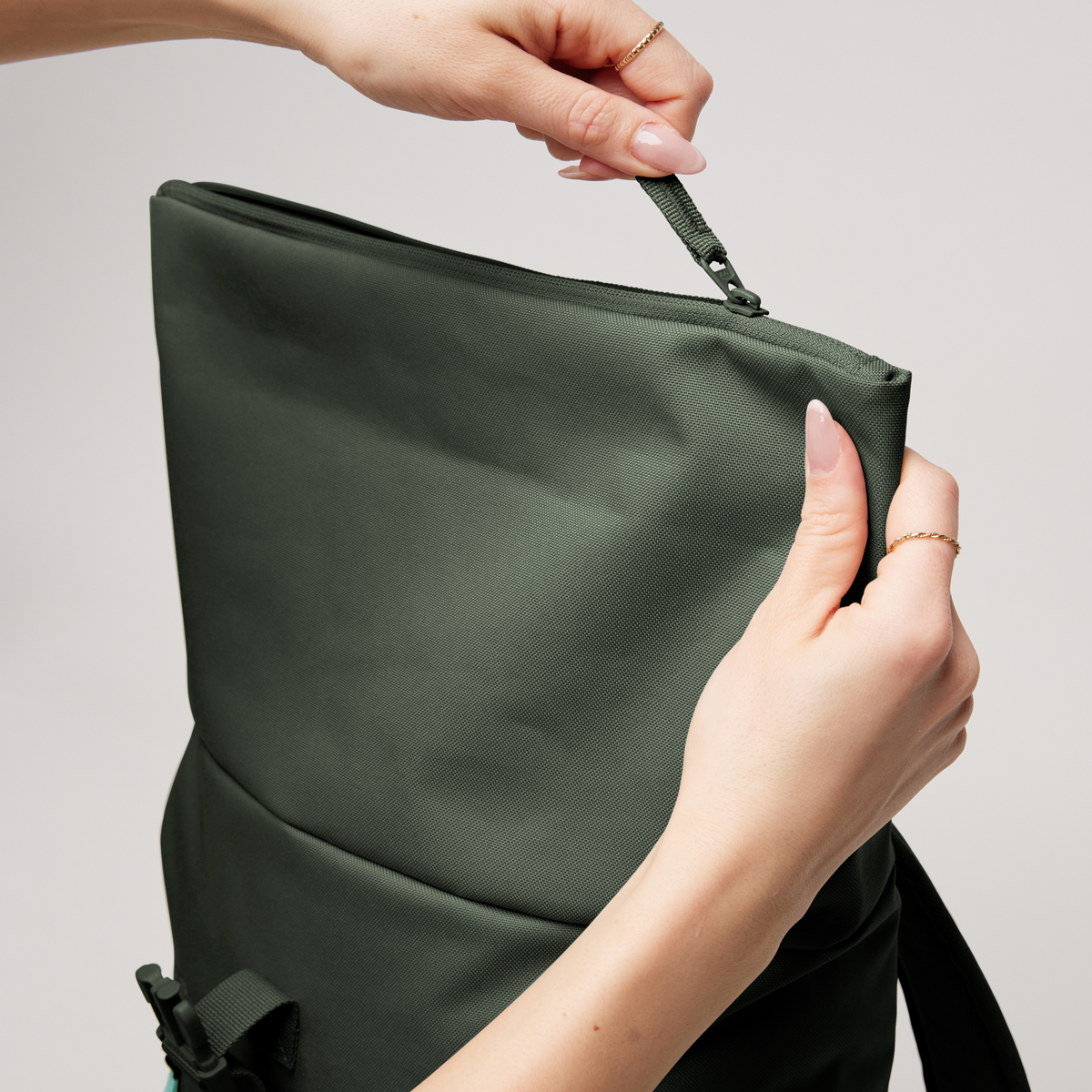 ROLLTOP EASY SMALL Rucksack in algae (Dunkelgrün mit Graustich) von einer Frau geöffnet.