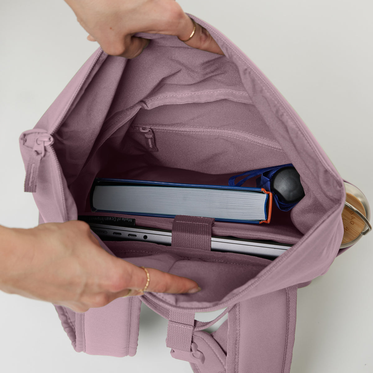 ROLLTOP EASY SMALL Rucksack in calamary (Altrosa) geöffnet mit Blick ins Innere, befüllt mit Laptop, Buch und Flasche.