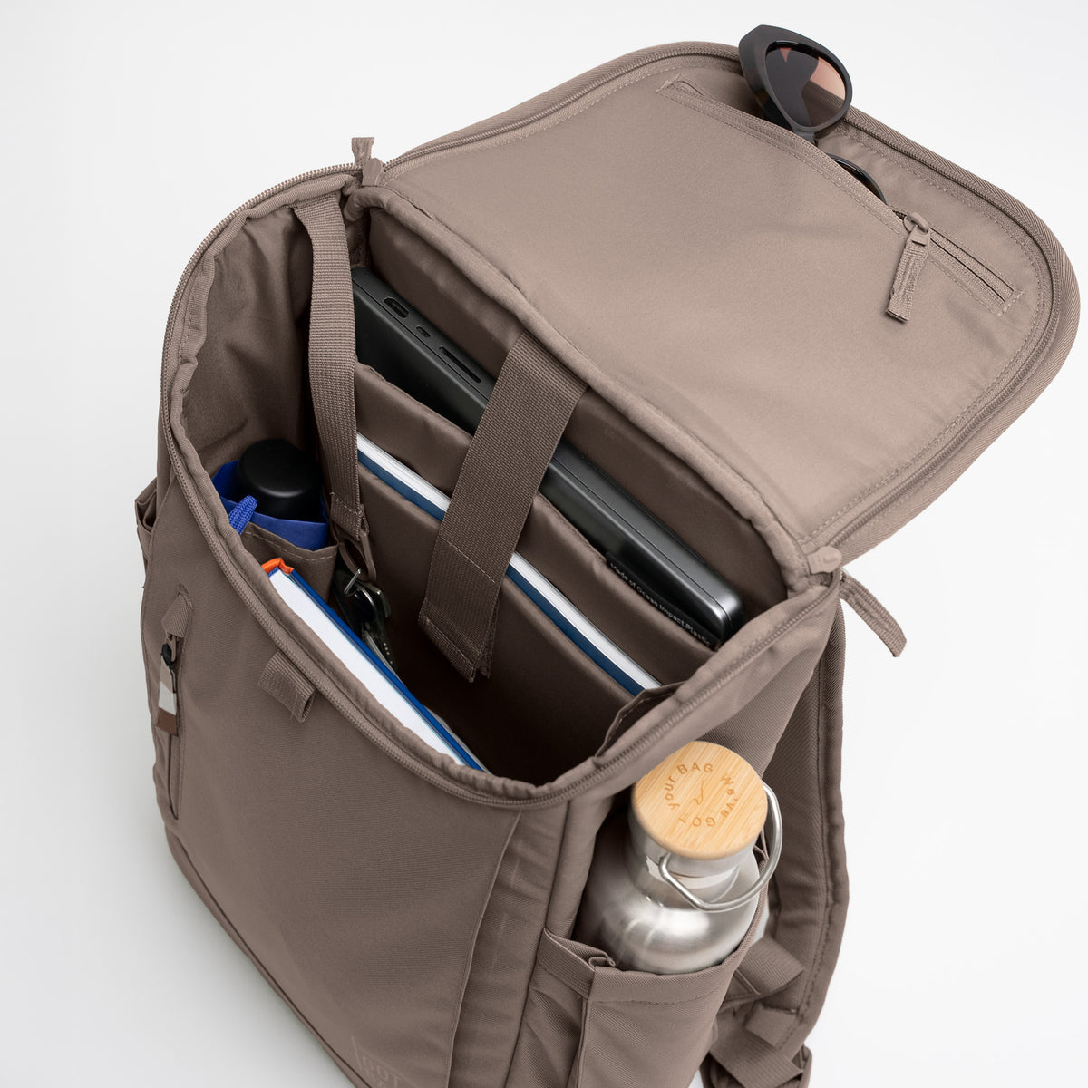 SERENE PACK Rucksack in oyster (klassisches Taupe-Braun) offen von oben mit Inhalt.