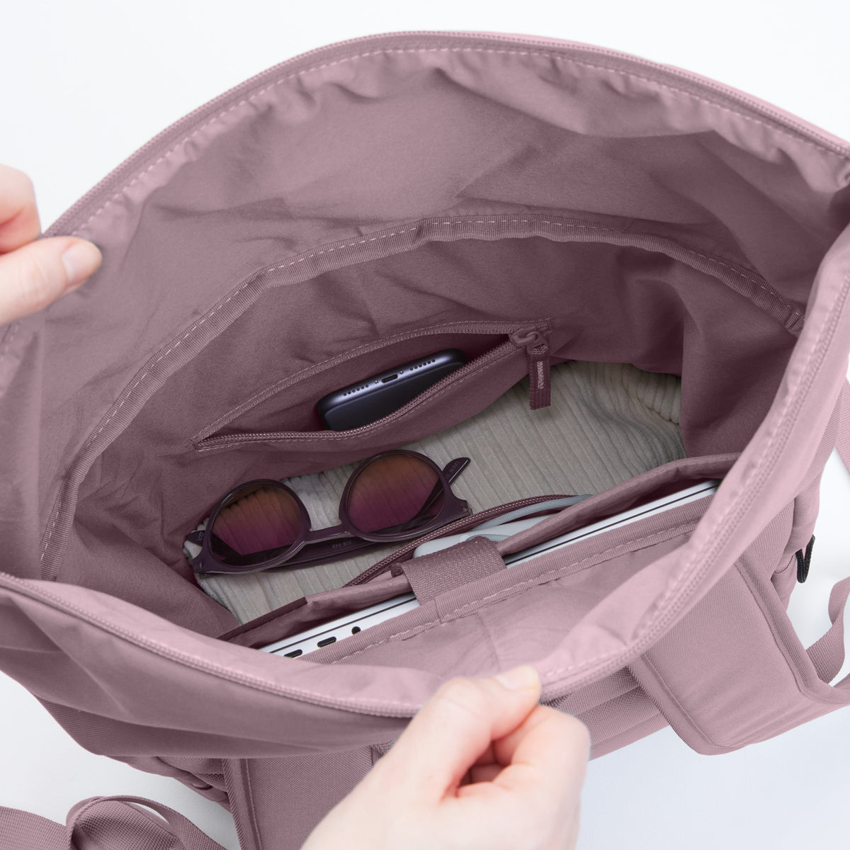 ROLLTOP EASY Rucksack in calamary (Altrosa) mit Blick ins Innere, sichtbar sind Smartphone, Sonnenbrille und Laptop.