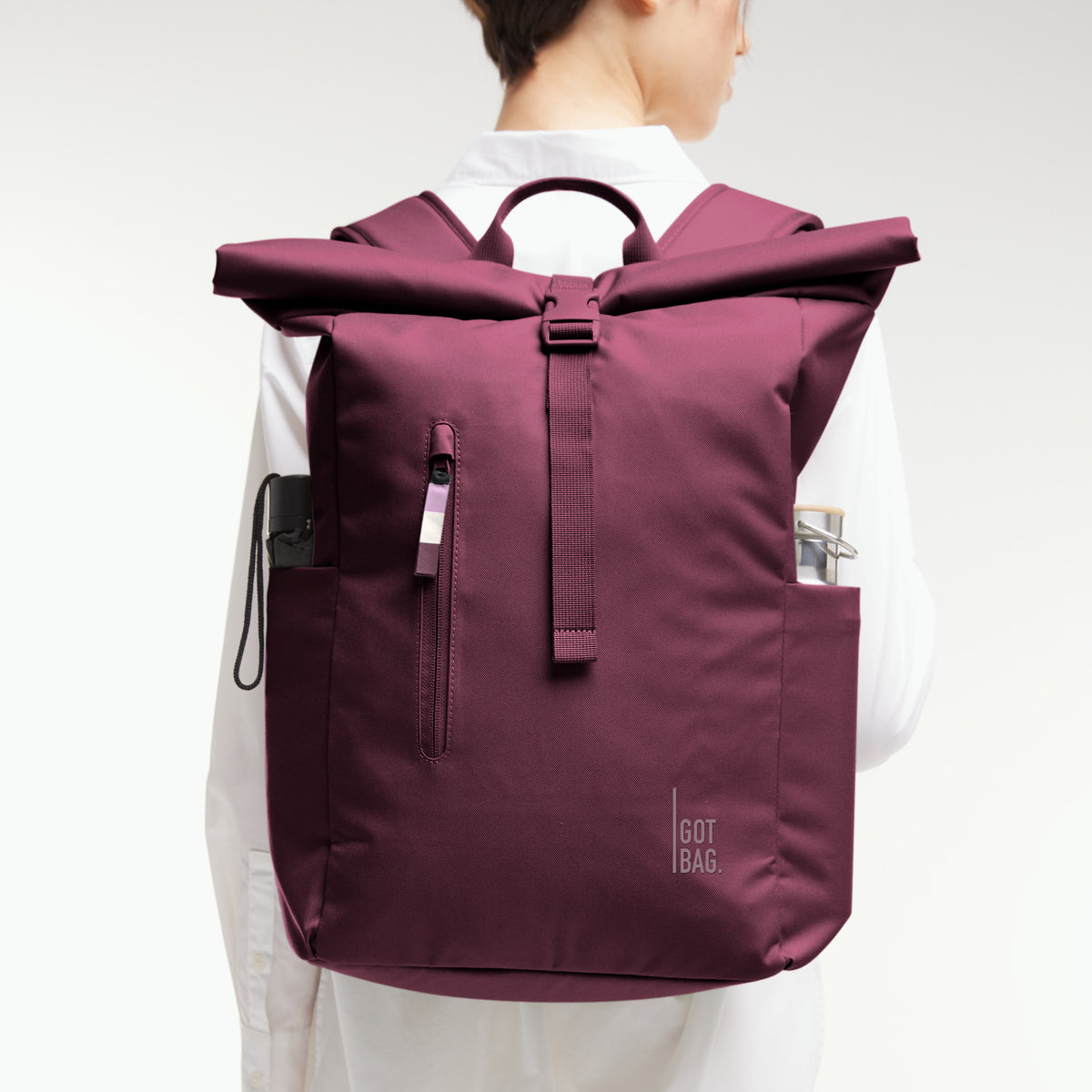 ROLLTOP EASY Monochrome Edition Rucksack in kraken (Weinrot) von einer Frau als Rucksack auf dem Rücken getragen.