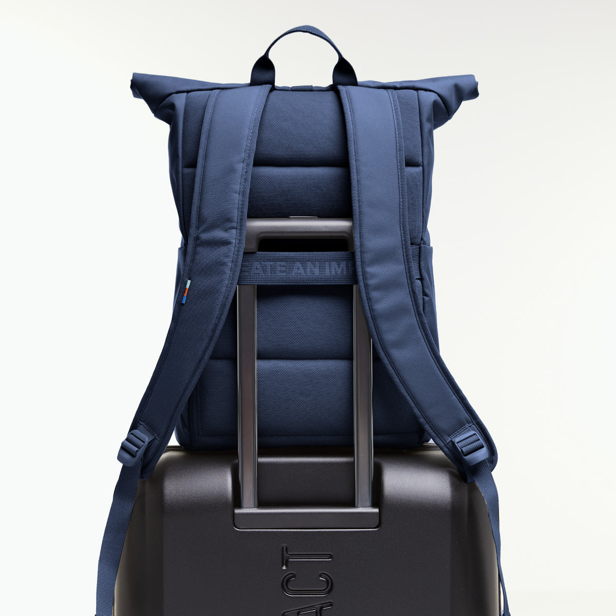 ROLLTOP EASY Rucksack in deep ocean (dunkles Marineblau) auf einem Koffergriff platziert, Rückansicht.