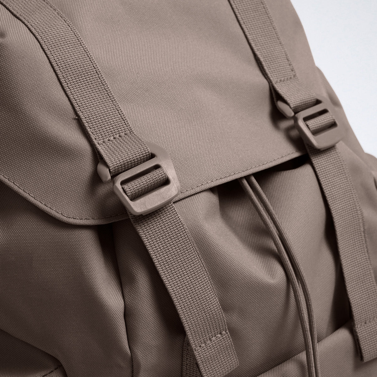 FLAP PACK LARGE Rucksack in oyster (klassisches Taupe-Braun) Detailaufnahme der Schnallen und des Kordelzugs.