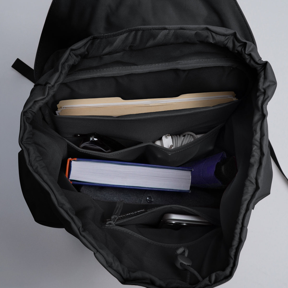 FLAP PACK LARGE Rucksack in black (Schwarz), geöffnet, zeigt die Innenfächer mit organisiertem Inhalt.