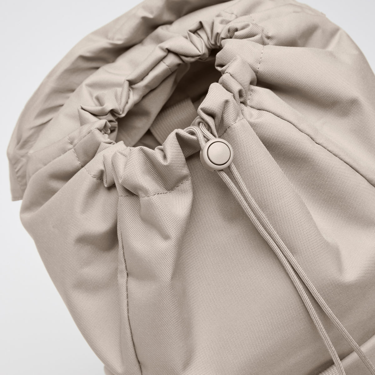 FLAP PACK LARGE Rucksack in scallop (helles Beige) mit geöffnetem Kordelzugverschluss, Detailaufnahme.