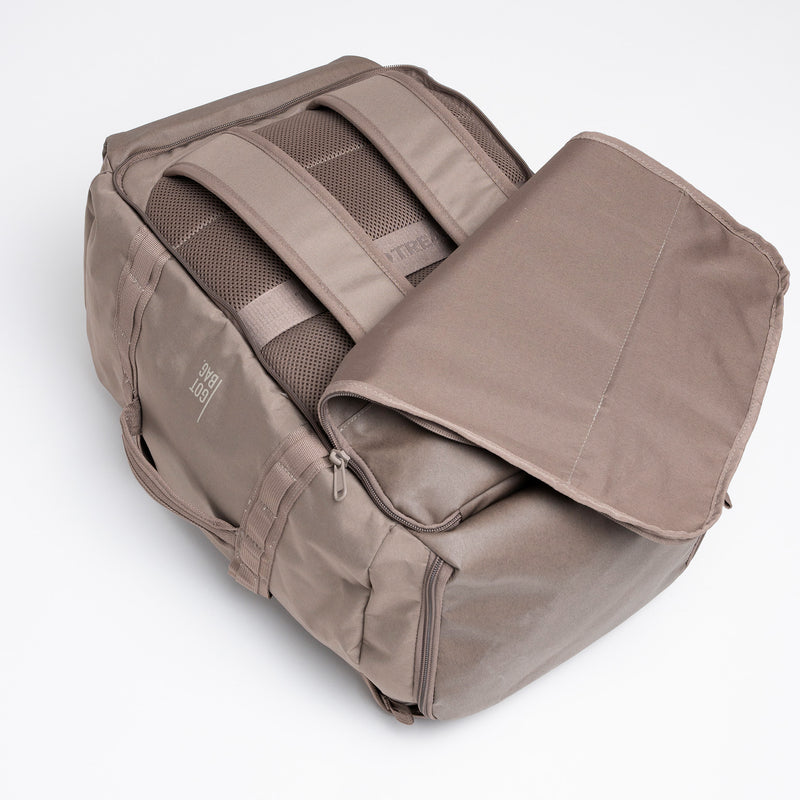 DUFFLE PACK Rucksack in oyster (klassisches Taupe-Braun) auf weißem Hintergrund, von oben geöffnet.