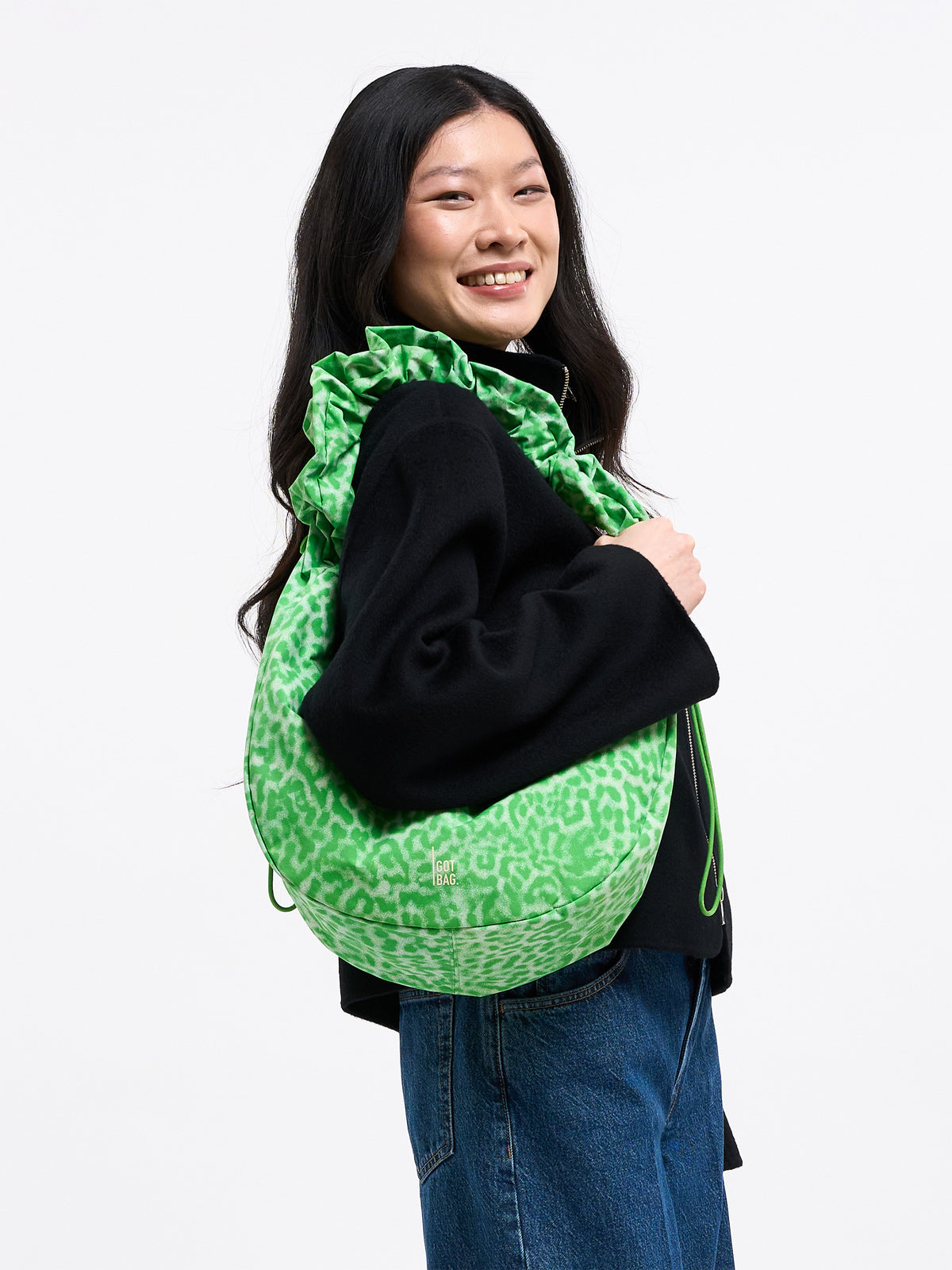 MOON BAG RUFFLE Tasche in shark (Dunkelgrau) von einer Frau über der Schulter getragen.