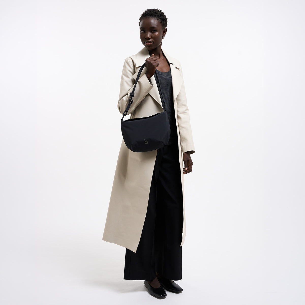CLAM BAG Tasche in black (Schwarz) von einer Frau in der Hand gehalten.